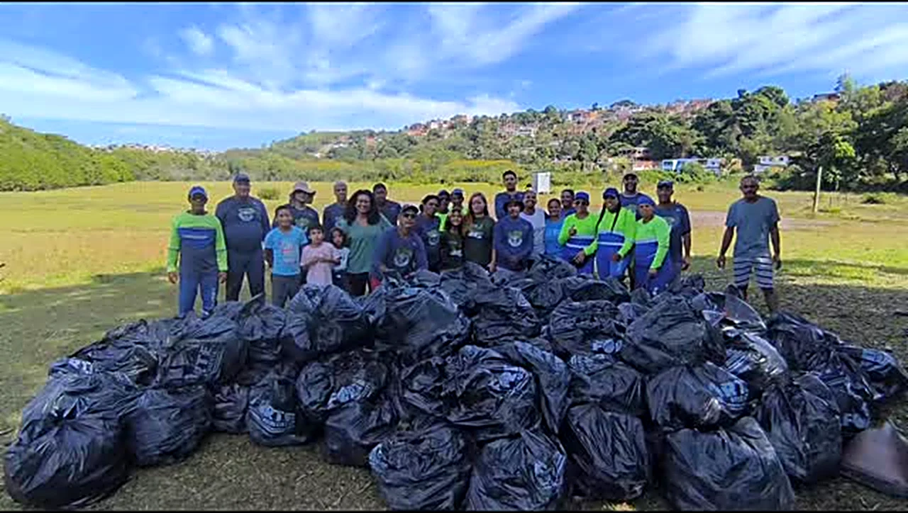 Voluntários do Projeto Mangue Limpo ES reunidos atrás de dezenas de sacos de lixo coletados em um mutirão
